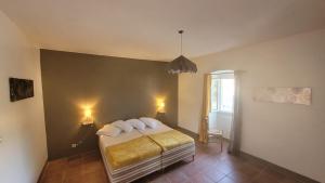 a bedroom with a bed with white pillows on it at Domaine Ostriconi in Palasca
