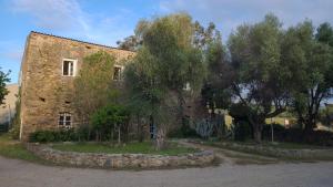 an old stone building with trees in front of it at Domaine Ostriconi in Palasca