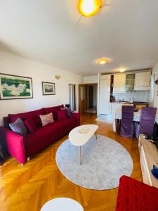 sala de estar con sofá rojo y mesa en Peace Sea View Apartment, en Makarska