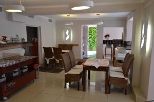 a dining room and living room with a table and chairs at Willa Allegra in Międzyzdroje