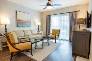 ein Wohnzimmer mit einer Couch und Stühlen und einem Tisch in der Unterkunft WorldMark Orlando Kingstown Reef in Orlando