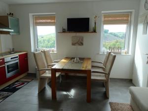 een keuken en eetkamer met een houten tafel en stoelen bij Ferienwohnung Büren-Harth in Büren