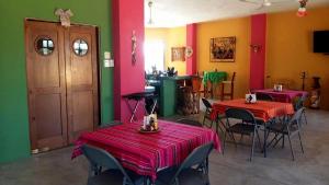 Pescadero的住宿－Hotel Boutique Las Terrazas，餐厅设有两张桌子和椅子,拥有红色和绿色的墙壁