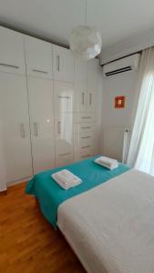 a bedroom with a bed and white cabinets at Think Home, exploring the center of Thessaloniki in Thessaloniki