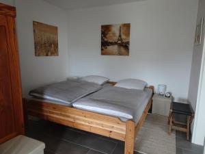een slaapkamer met een houten bed in een kamer bij Ferienwohnung Büren-Harth in Büren