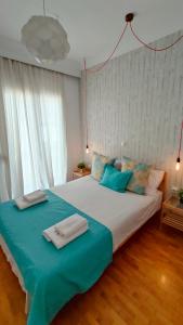 a bedroom with a large bed with blue pillows at Think Home, exploring the center of Thessaloniki in Thessaloniki