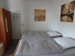 een slaapkamer met een bed en twee foto's aan de muur bij Ferienwohnung Büren-Harth in Büren