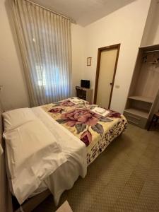 una camera con letto in una stanza con specchio di Hotel Aurora a La Spezia
