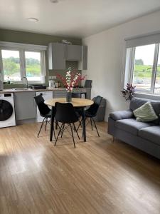 a kitchen and living room with a table and a couch at Peacock Farm Estate Self Contained Lodges in Cork