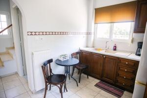 a kitchen with a table and chairs and a sink at Nous Dios in Xilokéra