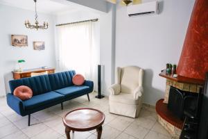 a living room with a blue couch and a chair at Nous Dios in Xilokéra