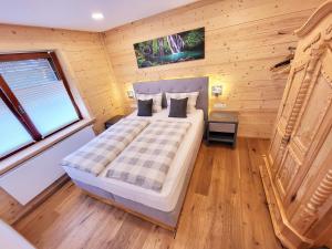 1 dormitorio con 1 cama en una habitación de madera en Schickster Sky Lodge, en Leutasch