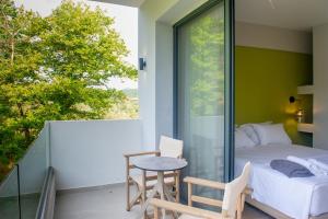a bedroom with a bed and a table on a balcony at domus hospitality in Vourvourou +75 photos