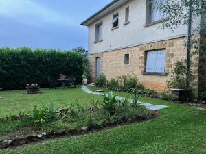 a house with a yard with a table and a patio at La Chambre l'Oree du bois in Capdrot