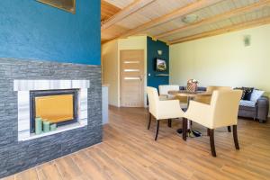 a living room with a fireplace and a table and chairs at Apartamenty Golden Village in Duszniki Zdrój