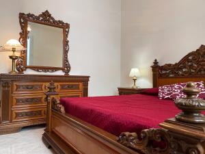 a bedroom with a large wooden bed with a mirror at Selinunte Street House in Castelvetrano Selinunte