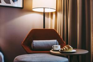 einen Tisch mit einer Tasse Kaffee und einem Teller Essen in der Unterkunft Crowne Plaza Belgrade, an IHG Hotel in Belgrad