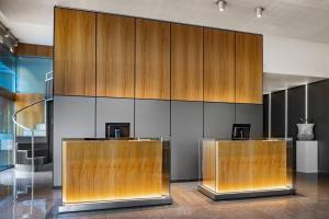 a lobby with two reception desks with wood panels at AC Hotel Diagonal L'Illa by Marriott in Barcelona