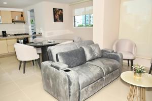 a living room with a couch and a kitchen at De estreno, nuevo apto en Barranquilla in Barranquilla