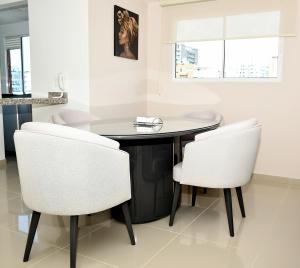 a dining room with a table and two white chairs at Apartamento familiar con excelente ubicación Barranquilla in Barranquilla +18 photos