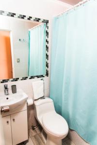 a bathroom with a toilet and a sink and a mirror at Hostal Tulvak Atacama in San Pedro de Atacama