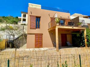une maison avec un balcon au sommet d'une clôture dans l'établissement Maison U CASTAGNU, à Santa-Reparata-di-Balagna