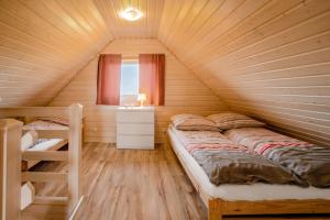 a bedroom with a bed in a wooden house at Havana Sarbinowo in Sarbinowo