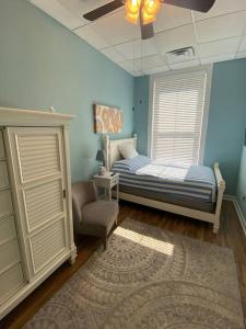 een slaapkamer met een bed, een stoel en een raam bij Turner's loft / sleeps 4 in the heart of the town in Wilmington