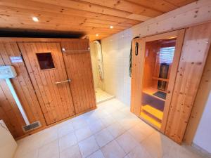 baño con puertas de madera y suelo de baldosa. en Schickster Sky Lodge, en Leutasch
