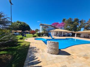 a swimming pool in a yard next to a house at POUSADA RECANTO SÃO JORGE in Águas de Lindoia