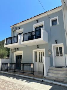 a white house with stairs and a balcony at Melintas cozy apartments 2 in Plomari