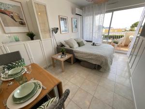 - un salon avec un lit et une table dans l'établissement Studio le Vue mer Accès direct à la plage Parking privé Clim belle terrasse, au Grau-du-Roi