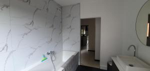 ein weißes Badezimmer mit Badewanne und Waschbecken in der Unterkunft D'Hestia - Gîte avec vue imprenable sur Huy in Huy + 29 Fotos