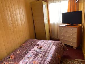 Dormitorio con cama y tocador con TV en Hospedaje & Alojamientos Hilda en Puerto Montt