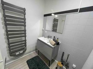 a white bathroom with a sink and a mirror at En Salvy : hyper centre + parking gratuit in Albi