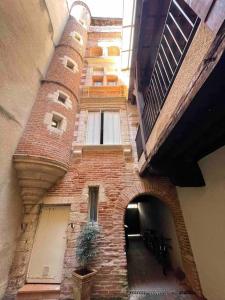 a brick building with an archway in a courtyard at En Salvy : hyper centre + parking gratuit in Albi