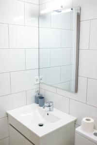uma casa de banho branca com um lavatório e um espelho em The Little Blondies 1 em Las Palmas de Gran Canaria