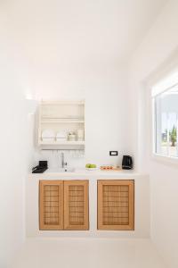 una cucina bianca con lavandino e finestra di Piccole Case a Kamari