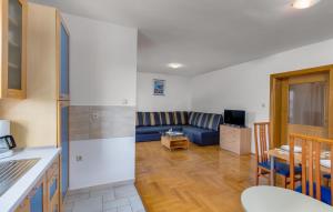 a kitchen and a living room with a blue couch at Apartments Dunja Malinska in Malinska