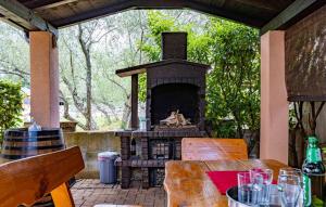 a outdoor table with a fireplace on a patio at Apartments Dunja Malinska in Malinska