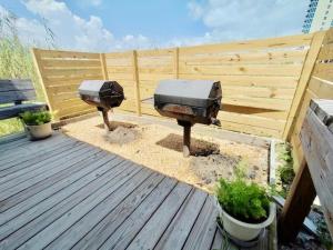 two barbecue bbqs on a deck with a wooden fence at Summer House West B103 in Gulf Shores