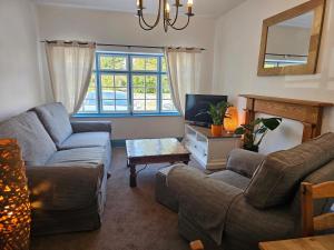 a living room with two couches and a tv at The Pack Horse Inn in Chathill