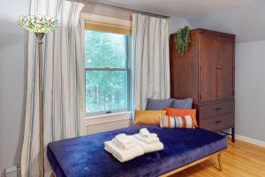 Un dormitorio con una cama azul con toallas. en Meadowhawk Haven, en Bath