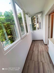 an empty room with windows and wooden floors at Maribelle Appartments in Târgovişte