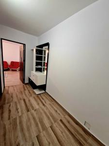 Habitación vacía con paredes blancas y suelo de madera. en Maribelle Appartments, en Târgovişte