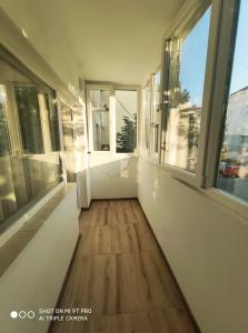 een lege kamer met ramen en een houten vloer bij Maribelle Appartments in Târgovişte