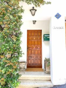 a wooden door on a white house with stairs at Casa Andorrana - ¡A Pie de todo! in Encamp