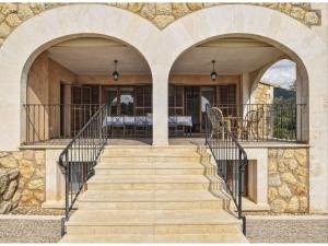 una escalera que conduce a una casa con dos arcos en Belvilla by OYO Pla de Ses Rotes, en Campanet