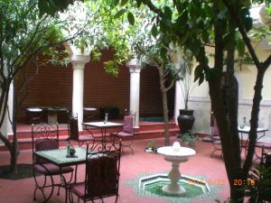un patio con mesas, sillas y árboles en Riad Sidi Ayoub, en Marrakech