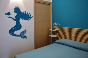 a bedroom with a mermaid stenciled on the wall at B&B Vivere il Mare in San Vito lo Capo